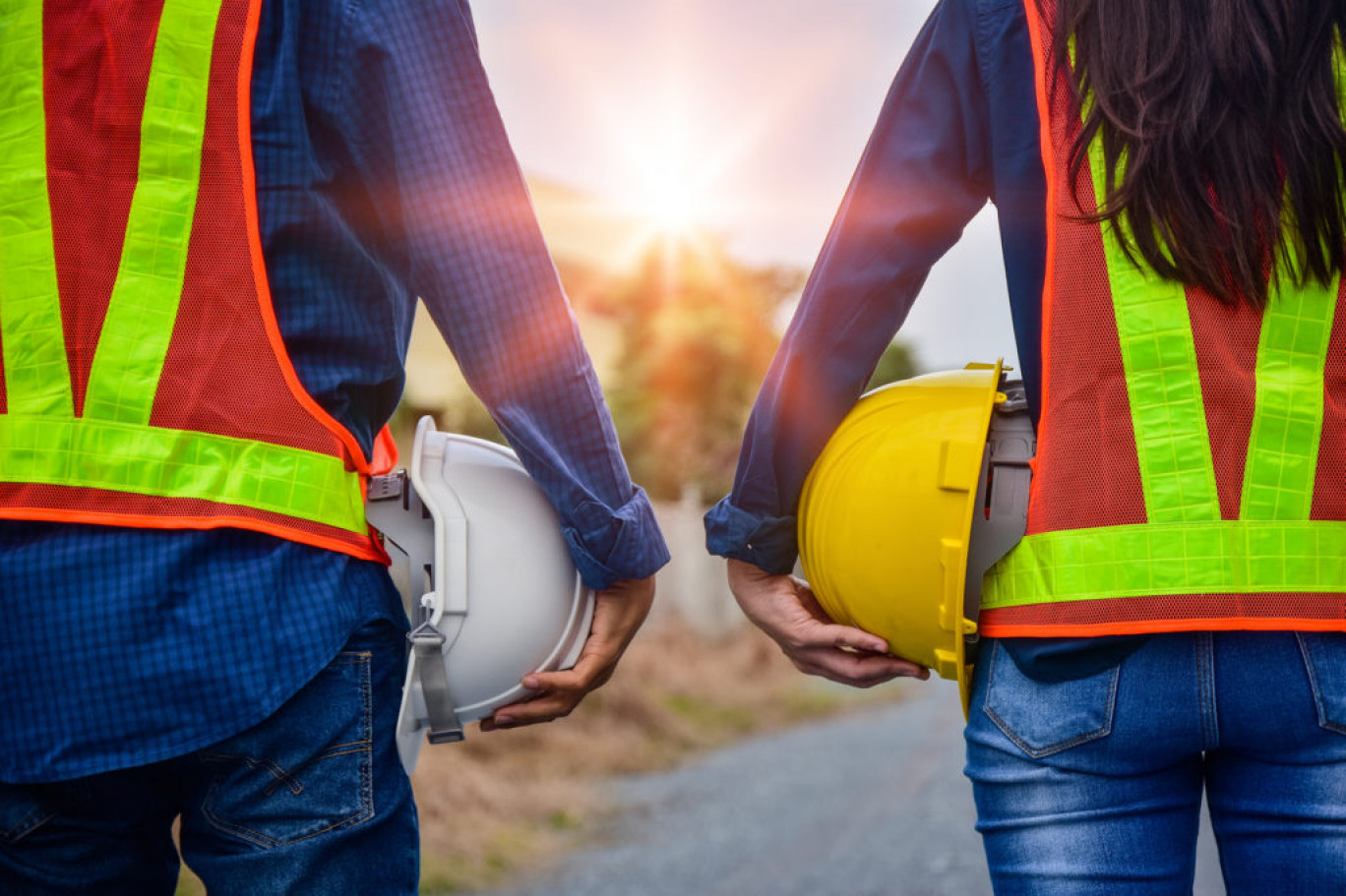 Man and Women Engineer holding hardhat safety Standing outdoor Teamwork management project